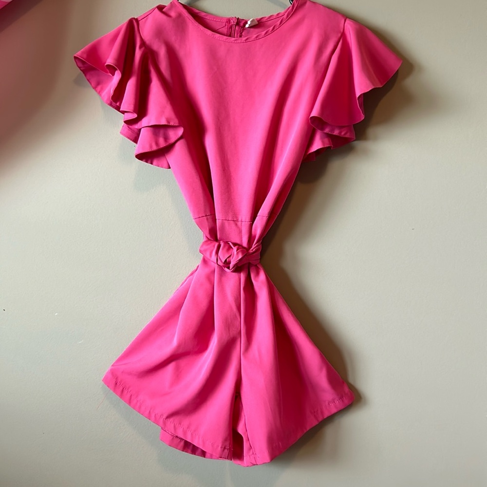 Pink romper and a zipper back and string that you can tie and untie.